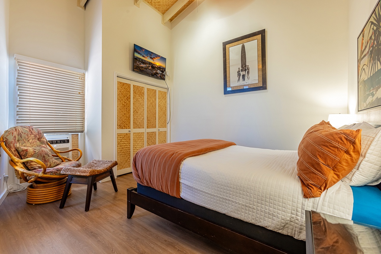 Slip into your cozy primary bedroom with vaulted wood-beam ceilings, crisp linens, and coastal-inspired decor that invites you to unwind in style.