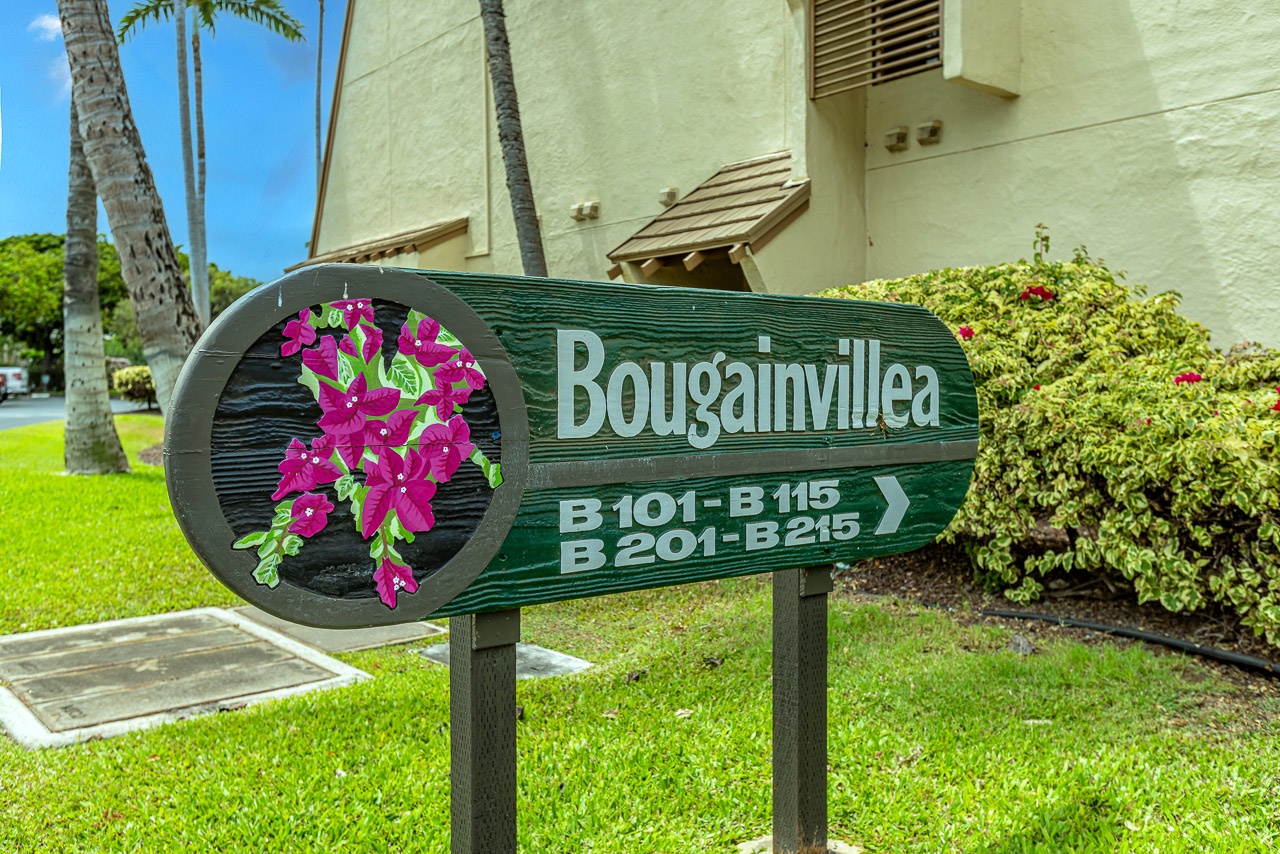 Property signage marks the entrance to Bougainvillea, providing clear directions to your unit amid tropical landscaping and palm trees.