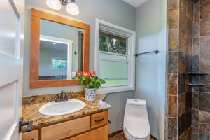 Guest bathroom at Pohaku Villa with modern vanity, shower, and fresh natural light.
