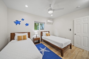Second view of the twin bedroom, offering bright windows and a comfortable layout for kids or friends traveling together.
