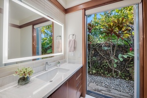 Guest Suite 3 bright ensuite bathroom with a sleek vanity and access to tropical garden views.