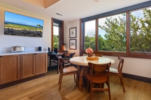 Your bright kitchen nook welcomes morning coffee with tropical garden views through expansive windows.