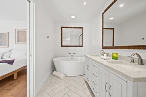 Unwind in this serene bathroom featuring a deep soaking tub and chic design.
