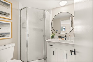 Sleek walk-in shower with modern finishes for a refreshing rinse after ocean adventures.