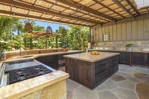 The fully-equipped outdoor kitchen has wide counter spaces for a convenient meal prepping.