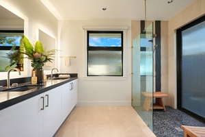 Spa-inspired bathroom with sleek finishes, a glass-enclosed shower, and serene ocean views.