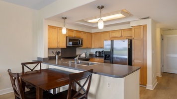 Cook with ease in the modern kitchen featuring stainless-steel appliances, ample counter space, and a breakfast bar for casual meals.