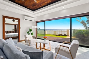 Luxurious living room with sliding doors leading to ocean and garden views.