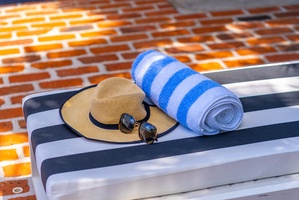 Lounge poolside with a fresh towel, your favorite sunglasses, and a sun hat—everything's ready for your perfect afternoon in the sun.