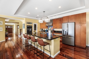 Bright, open kitchen with ample counter space, high-end appliances, and bar seating for four.