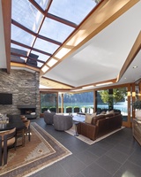 Sophisticated living area with a fireplace and panoramic waterfront views.
