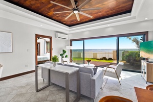 Living room with stylish decor, featuring panoramic views of the lush yard.
