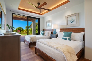 Spacious guest bedroom with two full size beds and views of the lush surroundings.