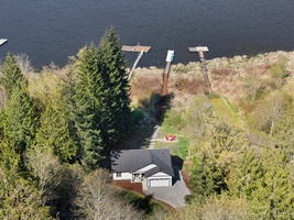 An aerial view shows off the home's stunning lakeside setting and private dock—ready to host your next serene retreat.