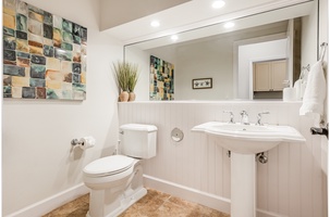 Bright and convenient powder room located downstairs next to the kitchen hallway