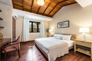 Guest Suite with king bed, wood-paneled ceiling, and serene garden views for a peaceful retreat.