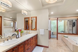 Primary ensuite with dual vanities, rich wood cabinetry, and spa-like finishes.