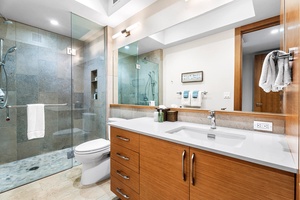 Spacious ensuite bathroom with glass walk-in shower and double vanity.