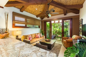 Guest cottage living room with vaulted ceilings and lush garden views.