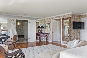 Spacious primary bedroom with a blend of modern and classic furnishings.