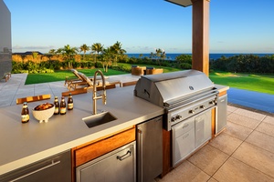 Fully equipped outdoor kitchen with a built-in grill, sink, and ocean views for alfresco dining.