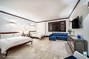 Sleep in this spacious guest bedroom offering two beds, a seating area, and a soothing ambiance.
