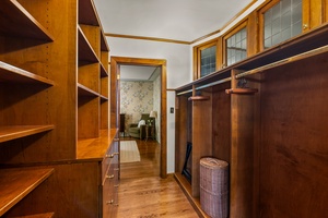 Walk-through closet with ample storage and shelving.