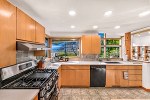 Prepare gourmet meals in style with a full gas range, dishwasher, and panoramic coastal views .