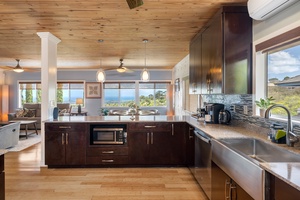 Modern stainless steel appliances, ample counter space, and garden-facing windows define this highly functional, stylish kitchen.