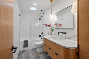 The upper-level shared bathroom with shower/tub combo and a single vanity.