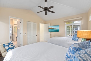 Drift off in this bright coastal bedroom with twin beds, ceiling fan, and tropical touches that promise peaceful sleep.