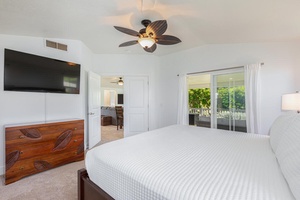 Airy primary bedroom with ceiling fan and direct garden views.