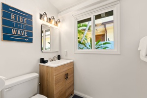 Step into a bright, coastal-inspired bathroom with warm wood accents, soft lighting, and a window framing glimpses of tropical greenery—your perfect retreat after a day of adventure.