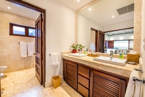 Full ensuite bathroom with wooden accents and ample lighting.