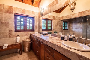 The primary ensuite bathroom also features a wooden window allowing natural light.