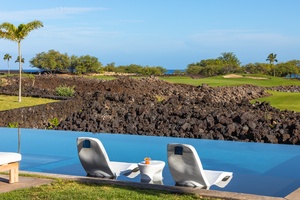 Stunning infinity pool overlooks volcanic landscape and championship golf course on Hawaii's pristine coastline.