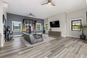 The wellness and fitness room comes with weights & exercise equipment for an in-home workout or yoga session and a small fridge for a cool post-workout drink