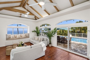 Elegant living room where exposed beams meet ocean views, perfect for morning coffee while watching the sunrise over paradise.