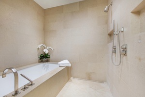 Indulge in spa-like serenity with a luxurious soaking tub and walk-in shower in the elegant primary en suite bathroom.