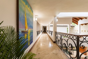 Beautifully designed hallway with decorative railings and artwork, leading to the various rooms of the house.