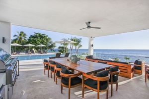 Enjoy outdoor dining with ocean views, complete with a large table and barbecue area.