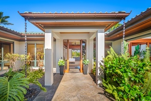 Grand entryway framed by tropical plants and a welcoming gated pathway.