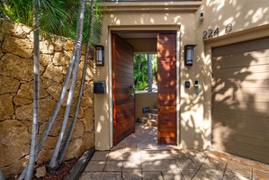Modern entrance with tropical landscaping creates a welcoming arrival at this beautifully designed property.