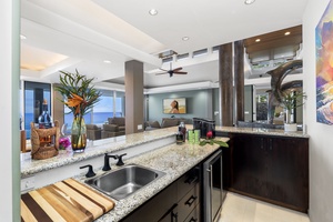 Bar area features granite countertops and premium appliances, opening seamlessly to the living area where ocean views await.