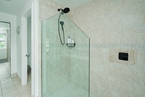 Step into your spacious glass-enclosed shower with premium fixtures and convenient toiletry shelf for a refreshing start to your day.