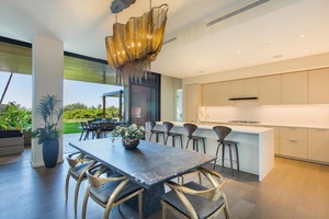 Your stunning open-plan kitchen flows seamlessly into the dining area, where you'll gather around the sleek marble table under a designer chandelier.