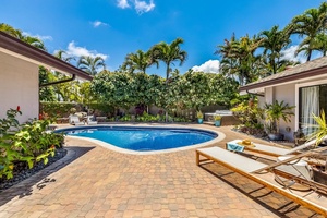 Tranquil pool deck with a jacuzzi and waterfall.