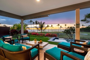 Luxurious patio with vibrant furniture and a breathtaking oceanfront view at dusk.