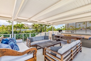 Rooftop deck with built-in BBQ, lounge, and dining spaces with peekaboo ocean views.