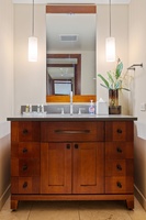 Step into your private bathroom with stylish pendant lighting, elegant wood cabinetry, and thoughtful details—like fresh botanicals and plush amenities waiting for you.